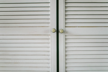 Fluted white wooden cupboard doors in the kitchen close-up