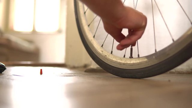 Inflate the tire of the bike. Remove the lid from the Bicycle wheel, lifts the valve and puts the pump on it. pumps the wheel, removes the pump and closes the lid.