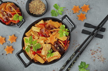 Fuji soy asparagus with vegetables in a black bowl. Pan-Asian cuisine, Korean asparagus salad