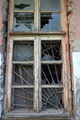 Old wooden window with a lattice and broken glass