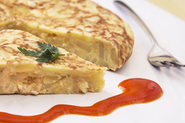 traditional spanish omelette dish with tomato sauce