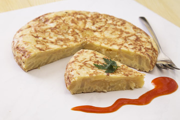 traditional spanish omelette dish with tomato sauce
