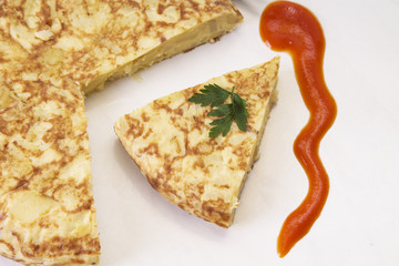 traditional spanish omelette dish with tomato sauce