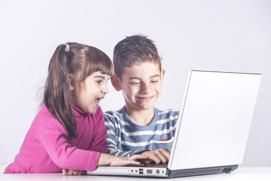 Kids having fun using a laptop computer. Education, technology and e-learning concept