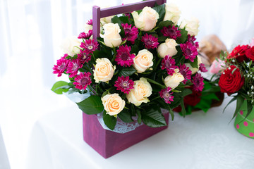 Bouquet of red and white flowers in wood box on table