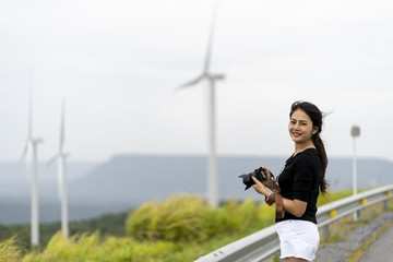 Asian women are very happy to photograph windmills and grasslands.