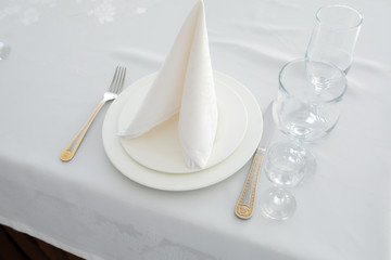 Elegant table lunch cutlery with white napkin fork and knife on white table