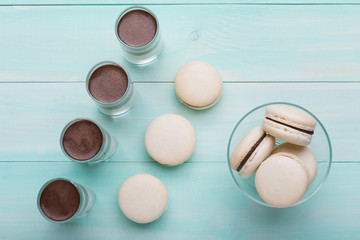 four glasses with chocolate dessert on turquoise boards, next to the French macaron, holiday concept, candy bar