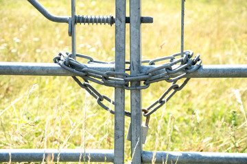 Metal chain and padlock around a metal gate