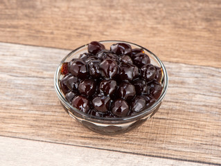 Tapioca Pearl , Bubble topping for tea or other beverage, in a cup, place on wooden table. Copy space