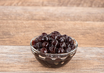 Tapioca Pearl , Bubble topping for tea or other beverage, in a cup, place on wooden table. Copy space