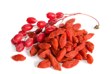 Branch of ripe red barberries and dried goji berries isolated on white background