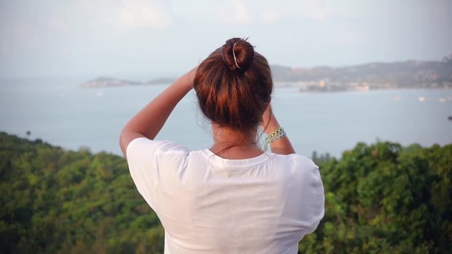 Girl tourist makes a photo of a beautiful view with mountains and sea on the phone. Slow motion, HD, 1920x1080