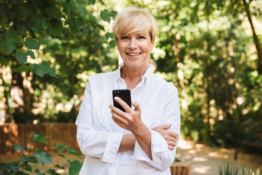 Happy mature woman using mobile phone