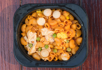 lunch box set of stir fried Macaroni with ketchup on wood table