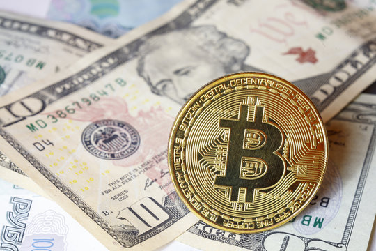cryptocurrency bitcoin, gold coin bitcoin on the background of us dollar banknotes close-up
