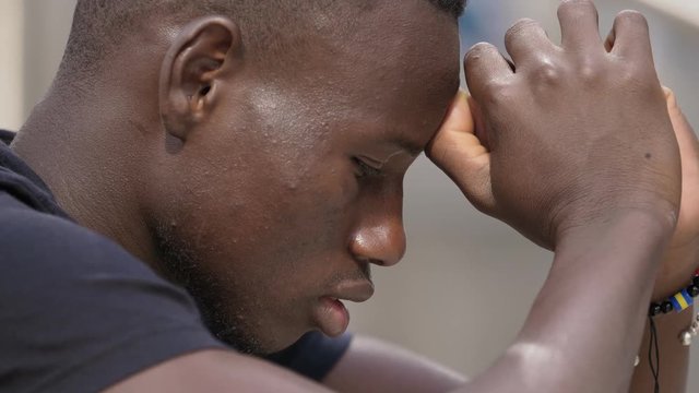 sad young attractive  African man  in prayer - outdoor