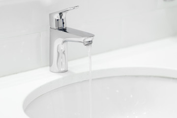 chrome crane on the ceramic wash basin in the bathroom close up