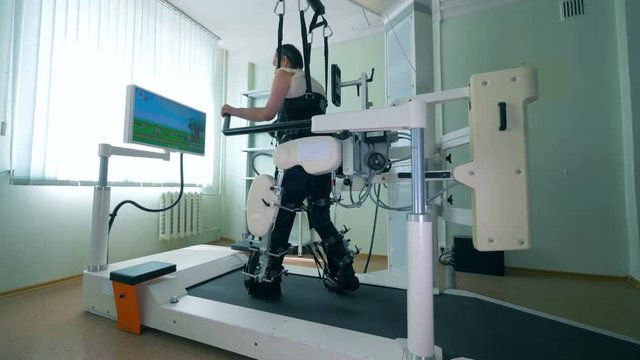 Paraplegic patient is practicing walking on a special simulator. Virtual reality simulator for patient rehab.
