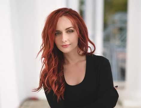 Portrait of attractive red haired young woman with blue eyes.