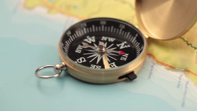 concept of travel, adventure, expedition, business, choice and possibilities - a golden compass lying on an abstract map with a red arrow that shows the direction