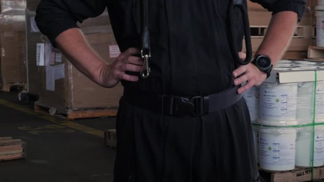 anonymous Polish customs officer talks on the backyard of warehouse