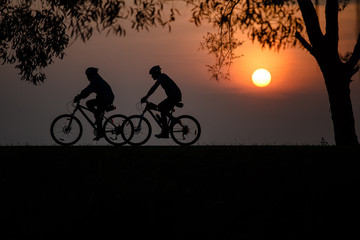 Obraz premium Shadow of cyclists with beautiful sun