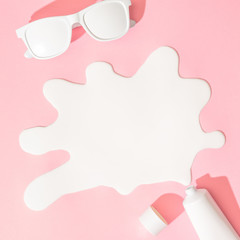 Creative layout with copy space, sunglasses and sunscreen or suntan lotion on pastel pink background. Minimal summer vacation concept. Flat lay.