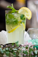 Mojito cocktail with lemon on table.