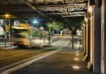Melbourne tram passes under railway bridge