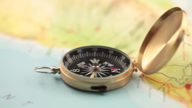 concept of travel, adventure, expedition, business, choice and possibilities - a golden compass lying on an abstract map with a red arrow that shows the direction