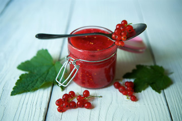 A glass jar of red currant jam.