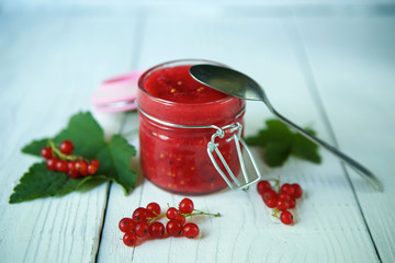 A glass jar of red currant jam.