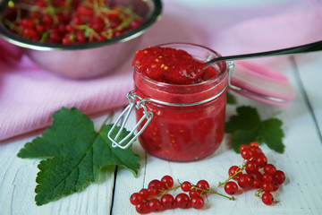 A glass jar of red currant jam.