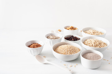 variaty of raw cereals and nuts for breakfast. Oatmeal flakes and steel cut, barley, walnut, chia, raisins. Healthy ingredients