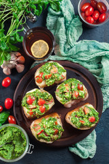 Bruschetta with fresh pesto, mozzarella and cherry tomatoes on cutting board