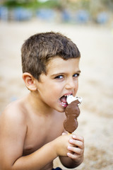 Little kid eating an ice cream at beach
