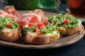 Bruschetta with fresh pesto, mozzarella and cherry tomatoes on a plate