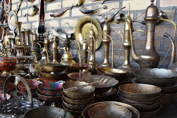 Fototapeta na wymiar Ancient East dishes. Teapots, cups, lamps, jugs, made of gold, brass, handmade silver. A shopkeeper's shop. Uzbek Oriental Traditions. Bukhara