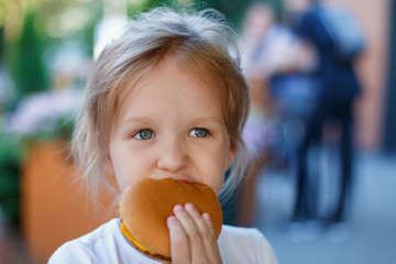 Little girl eating a hamurgeur