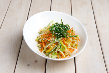 Salad with fresh cucumber, pepper, cabbage, carrot, seaweed and sesame