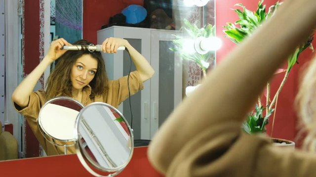 Young beautiful girl curls in the dressing room