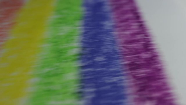 Closeup shots of rainbow painted with pastel crayons. Painted paper sliding into the frame. Rough texture of painted surface with intricate details. Colorful stripes, pride concept.