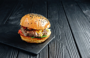 homemade  juicy burger on dark wooden board. Street food, fast food.