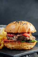 homemade  juicy burger on dark wooden board. Street food, fast food.