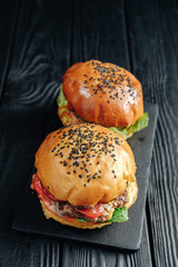 homemade juicy burgers on dark wooden board. Street food, fast food. top view