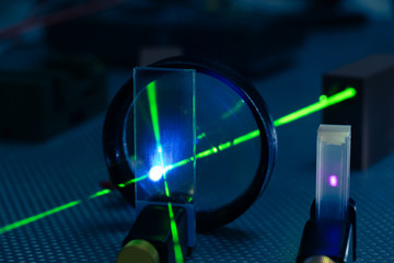 Green laser on optical table in a quantum optics lab. - obrazy, fototapety, plakaty