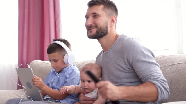 Excited father watching football with children