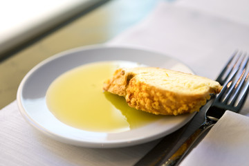 One slice of bread and olive oil in a white plate.
