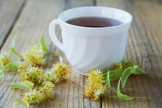 cup of tea with linden flowers on a rustic table
